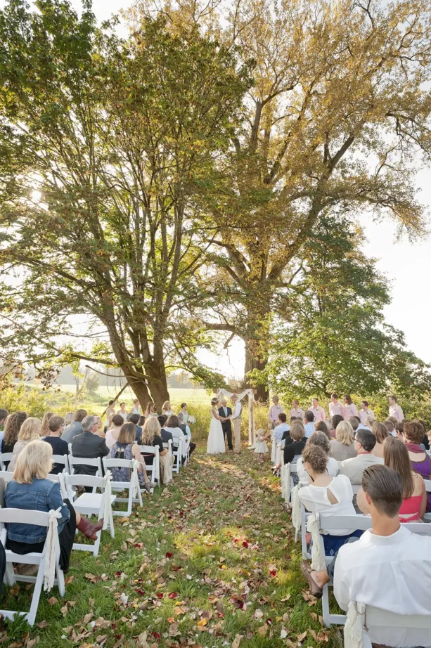 A wedding ceremony takes place in autumn near a cottonwood tree at Red Barn Studios in Chehalis, WA.