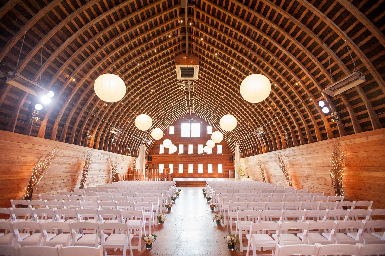 White resin chairs are set up for a wedding ceremony at Red Barn Studios in Chehalis, WA.