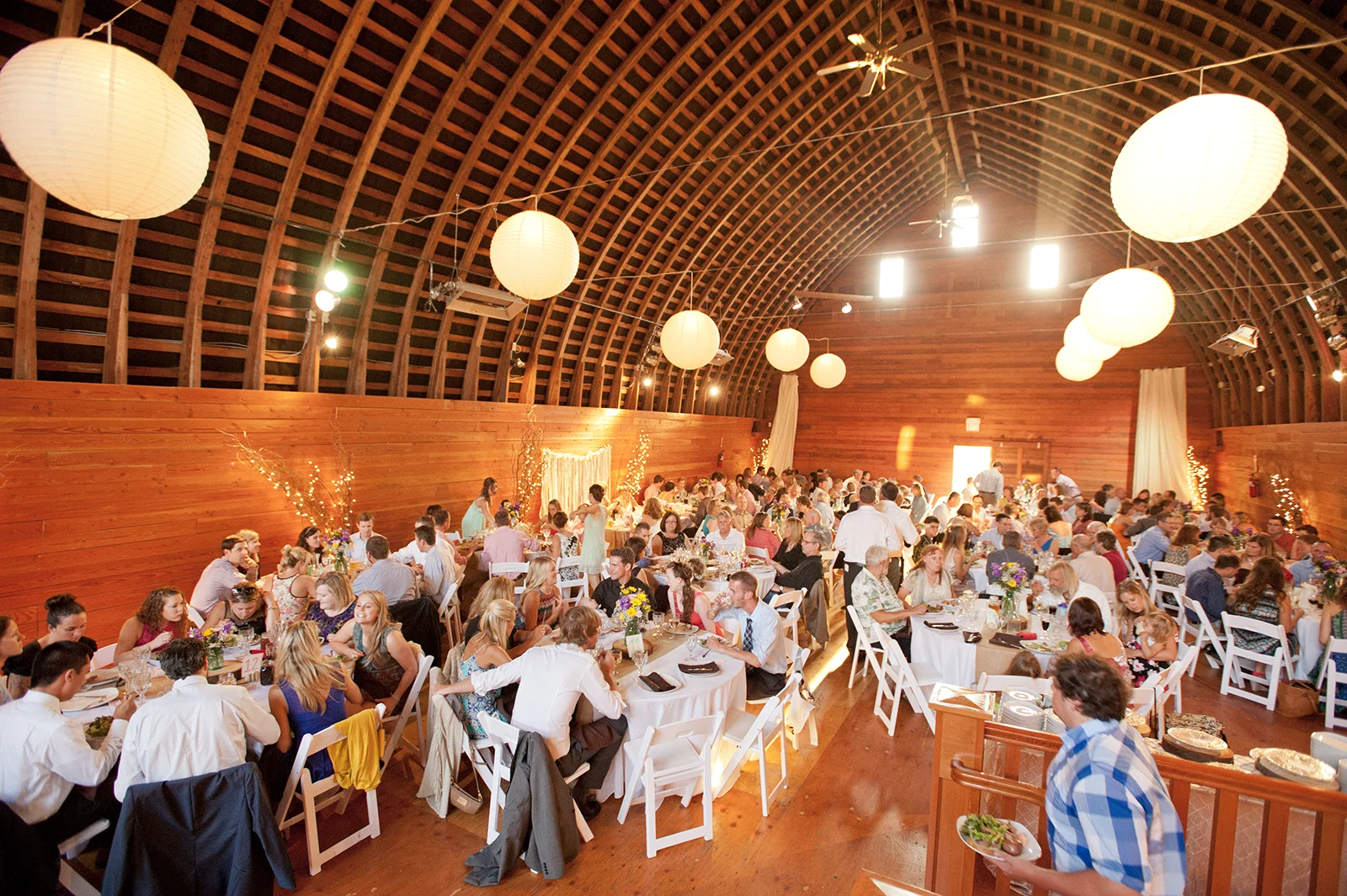 Wedding guests are seated at tables for dinner during a reception at Red Barn Studios in Chehalis, WA.